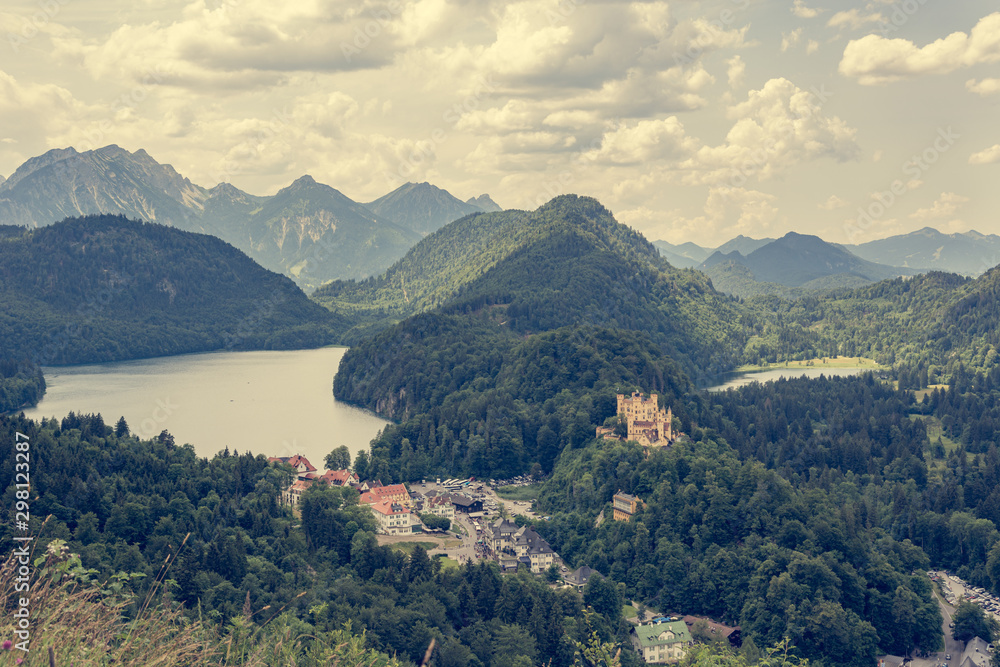 Picturesque view of Bavarian castle with lake surrounded with forest.