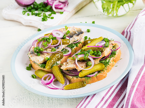 Canvas Print Traditional Dutch sandwich with herring and pickles cucumbers on white table