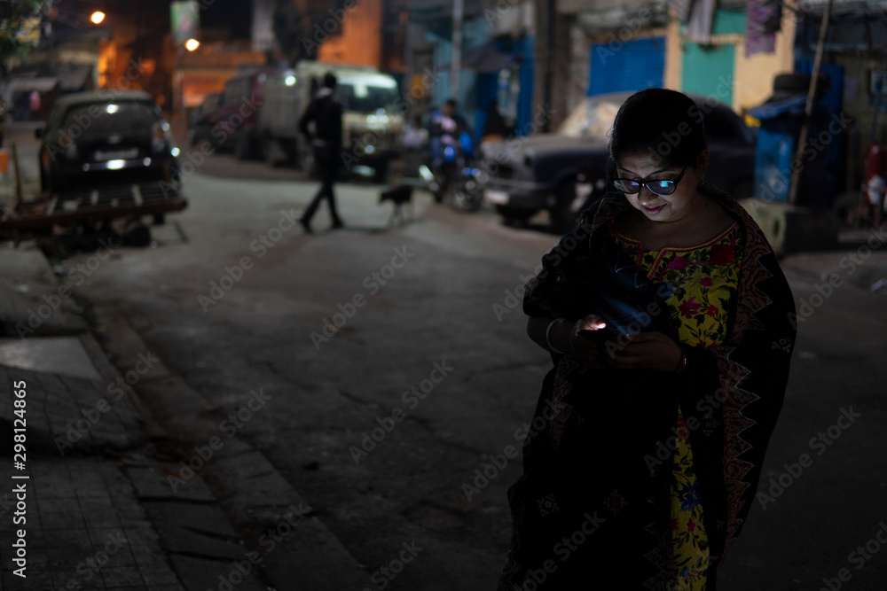 Woman browsing smartphone at night in the street Woman browsing smartphone at night in the street