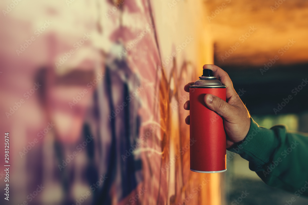 Obraz premium Street artist painting colorful graffiti on a wall.