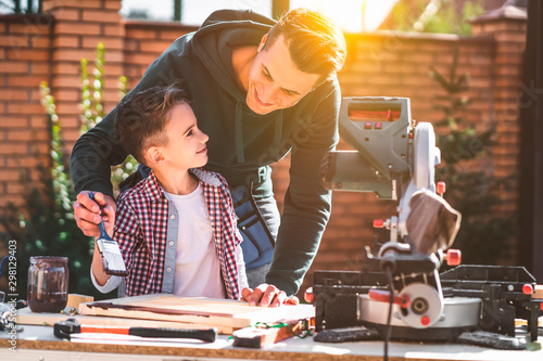 The father and his little son paint carpentry photo