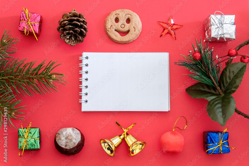 Obraz premium Creative Composition Useful for Christmas and New Year Greeting Card Created Using Gift Boxes, Christmas Bell, Pine Branch, Pine Cone, Chestnut, Cookie Smiley, Red Star and Blank Paper For Copy
