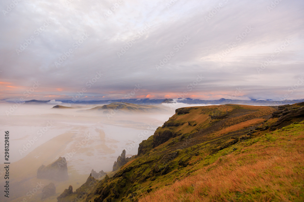 Amazing landscape with basalt rock formations Troll toes (Trolls fingers) on Black Beach. Ocean waves flow around stones. Midnight sun of Iceland. Reynisfjara beach, Vik. Visit Iceland. Beauty world.