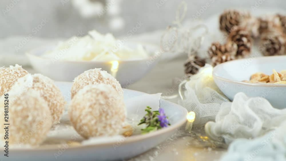 Homemade candies with coconut roasted almonds on a Christmas season table decorated with lights and stars. Homemade candies with coconut roasted almonds on a Christmas season table decorated with lights and stars.