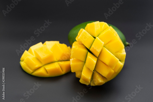 Sliced mango fruit isolated on a black background, ready to be served. Top view, healthy fruit breakfast or snack.