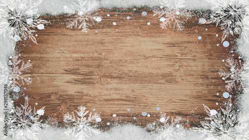 winter / Advent / christmas Background template - Frame made of snow with snowflakes and ice crystals on brown wooden texture, top view with space for text photo