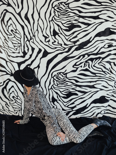 Anonymous stylish female looking at zebra wall photo