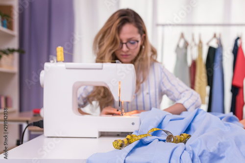 Young woman sewing on a sewing machine photo