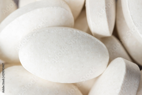 Group of white medical supplement pills, macro image