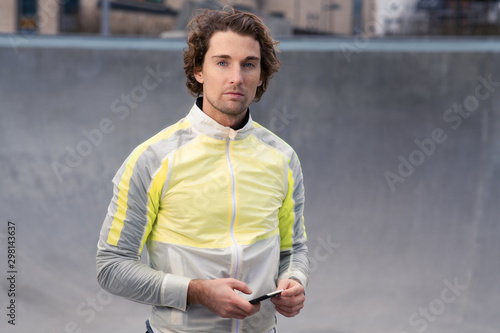 Portrait of attractive man holding smart phone in stylish active wear