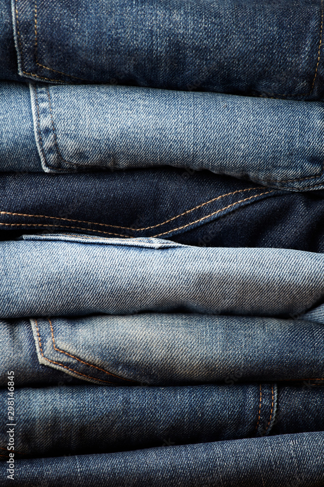 Stack of various blue jeans on black background. Beauty and fashion, clothing concept. Detail of nice blue jeans. Jeans texture or denim background. Collection of jeans. the blue jeans fabric details Stack of various blue jeans on black background. Beauty and fashion, clothing concept. Detail of nice blue jeans. Jeans texture or denim background. Collection of jeans. the blue jeans fabric details