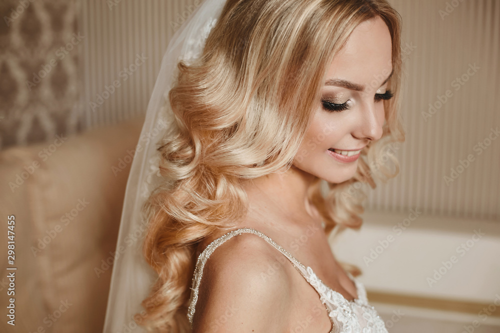 Happy blonde model girl with wavy wedding hairstyle and bright makeup in veil and wedding dress. Close up cropped portrait, copy space, background. Concept of happiness