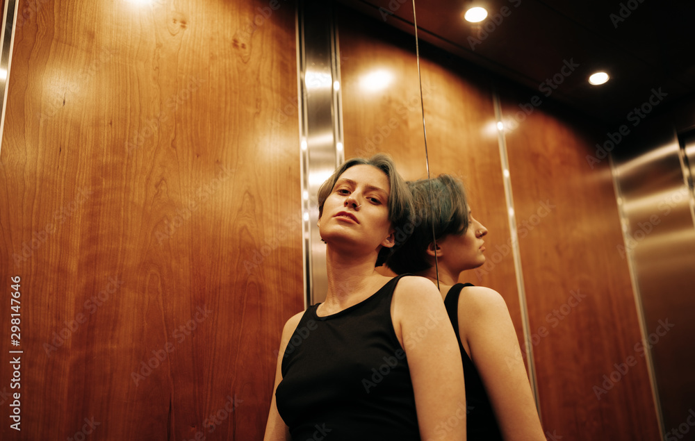 young androgyne woman standing In elevator young androgyne woman standing In elevator