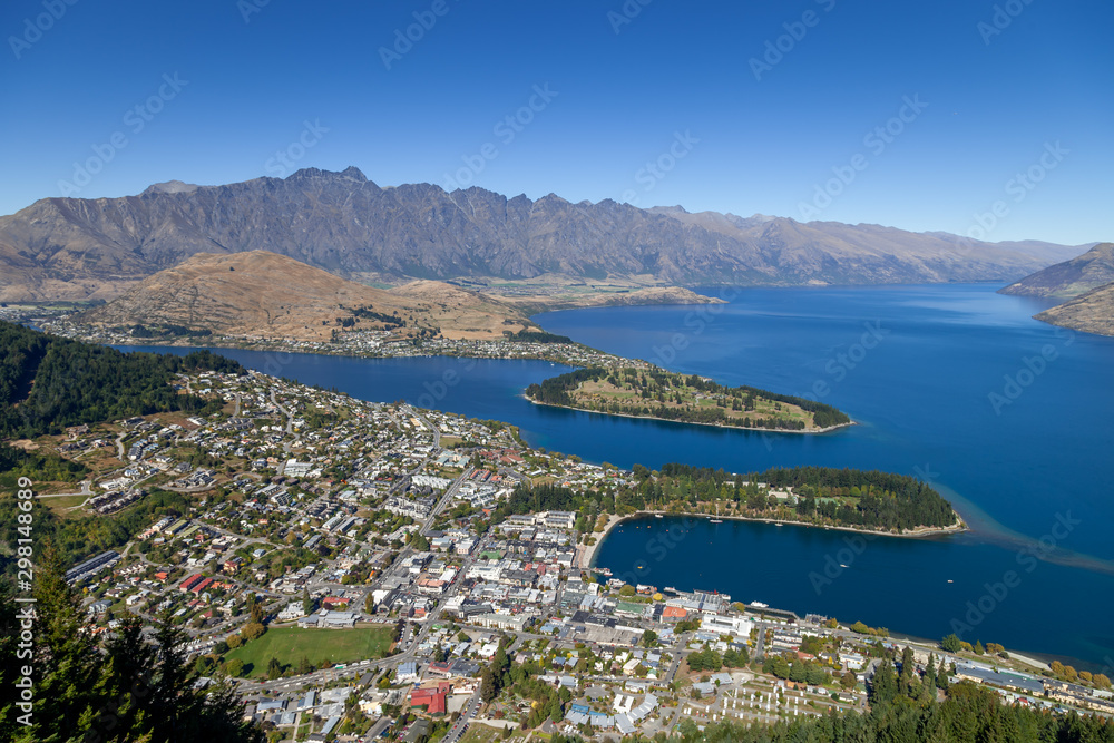 Queenstown, New Zealand in Autumn. The Queenstown peninsula and in the background the Remarkables are visible. Lake Wakatipu is deep blue.