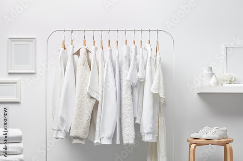 Cloakroom interior with clothes in white color