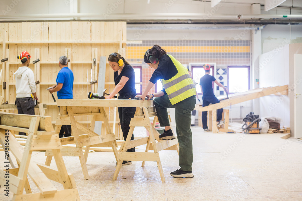 Carpenters working at illuminated workshop Carpenters working at illuminated workshop