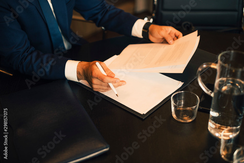 Midsection of lawyer reviewing evidence at legal office