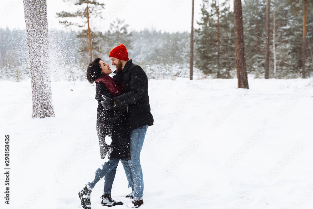 Loving guy and girl hug and have fun in the winter forest Loving guy and girl hug and have fun in the winter forest
