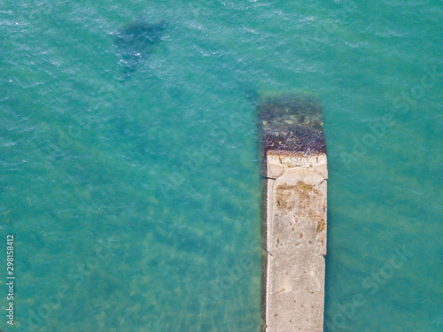 Sea pier on the sea blue water background. Aerial drone top down shot. © Igor Krivosheev