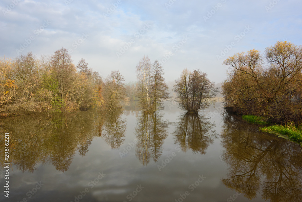 Morning on the river, trees are reflected in the water. Morning on the river, trees are reflected in the water.
