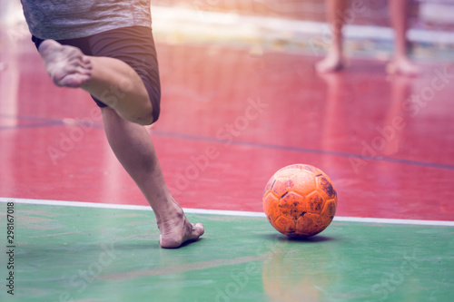 Futsal players barefoot. Futsal player control and shoot ball to goal. Indoor soccer sports hall. Football futsal player, Orange ball, Futsal floor.