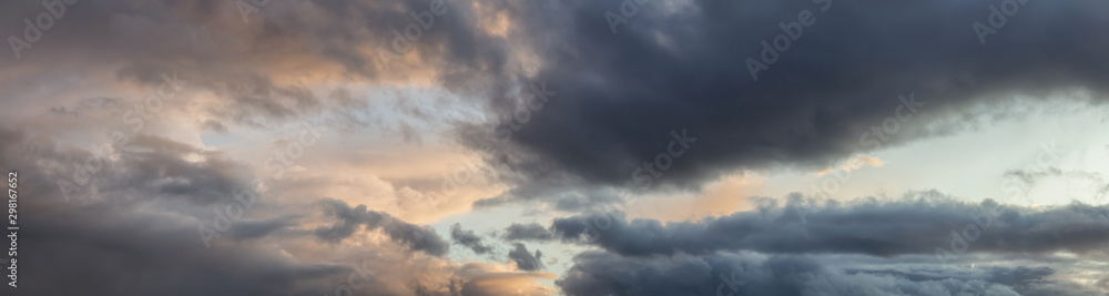 Dramatic Panoramic View of a cloudscape during a dark, rainy and colorful sunset. Taken in Alaska, USA.