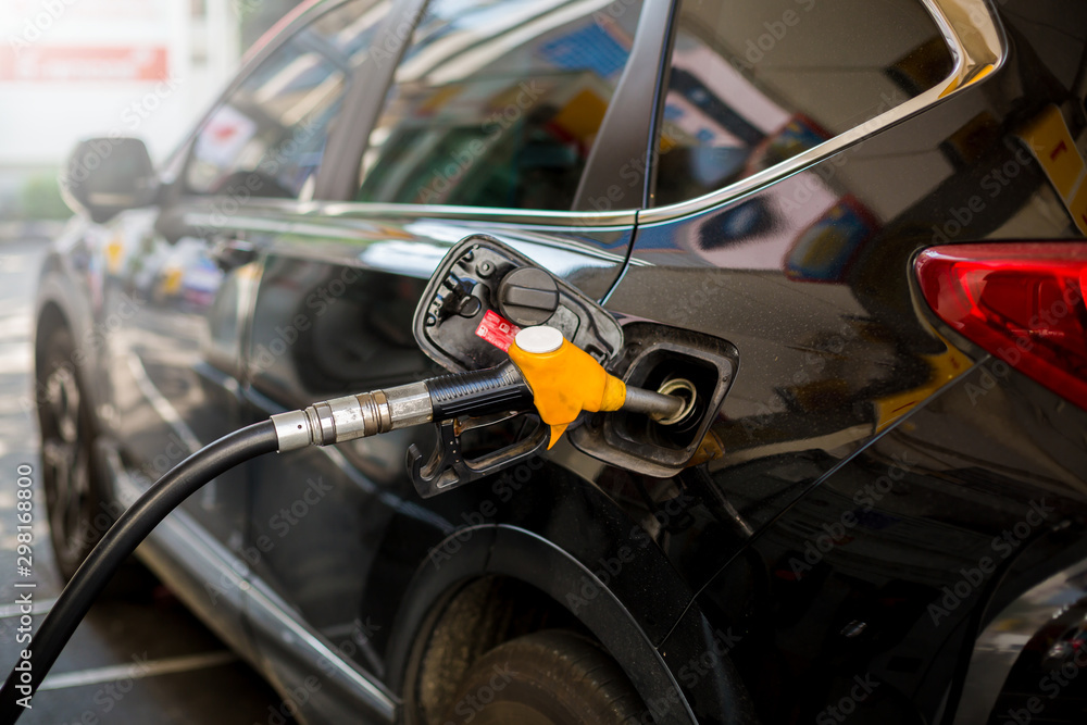 Hand refilling the black car with fuel at the gas station. Oil and gas energy. black car in gas station, refilling the car with fuel at the refuel station, the concept of fuel energy, selective focus. Hand refilling the black car with fuel at the gas station. Oil and gas energy. black car in gas station, refilling the car with fuel at the refuel station, the concept of fuel energy, selective focus.