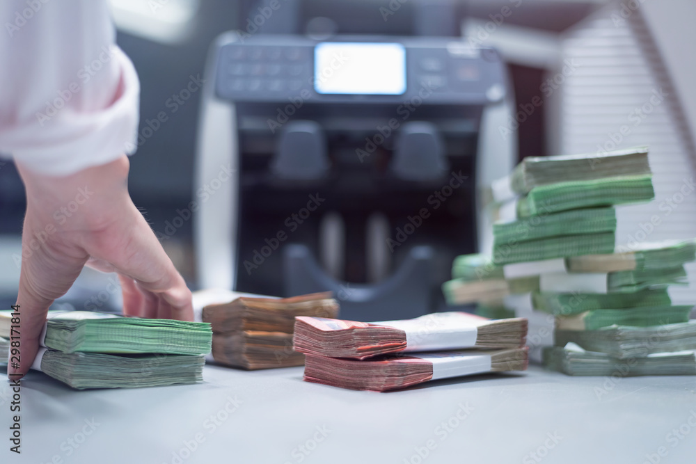 Bank employees sorting and counting money inside bank vault. Large