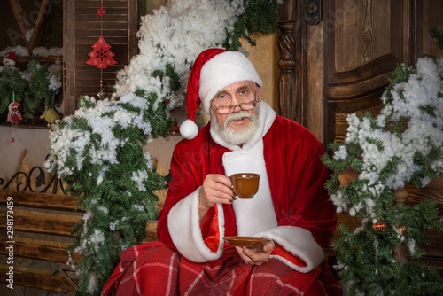 Santa Claus is drinking hot tea or coffee.