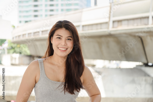 Portrait picture charming beautiful Asian long hair woman smiling and looking at camera in gray vest, Free Download Portrait picture charming beautiful Asian long hair woman smiling and looking at camera in gray vest, - GFXLoad