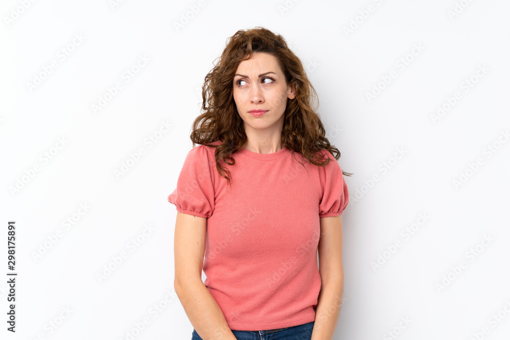 Young pretty woman over isolated background making doubts gesture looking side Young pretty woman over isolated background making doubts gesture looking side