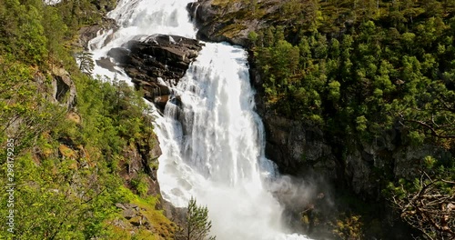 Kinsarvik, Hordaland, Norway. Waterfall Nyastolfossen In Hardangervidda Mountain Plateau. Nyastolsfossen in Spring Sunny Day. Height Of 115 m. Famous Norwegian Landmark And Popular Destination 4K photo