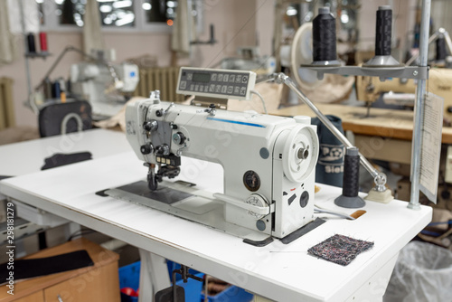 Industrial sewing machine in the work shop. Shoe manufacturing.