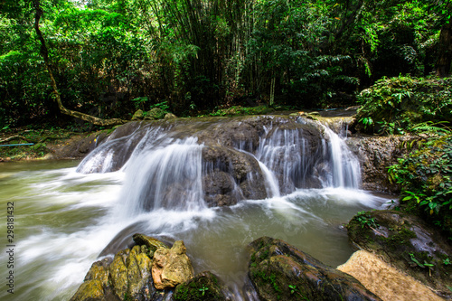 The natural background of waterfalls that blur the flow of water  with various tree species surrounded and boulders of various sizes  the beauty of the ecosystem and the jungles of forests.