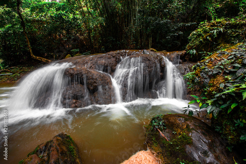 The natural background of waterfalls that blur the flow of water  with various tree species surrounded and boulders of various sizes  the beauty of the ecosystem and the jungles of forests.