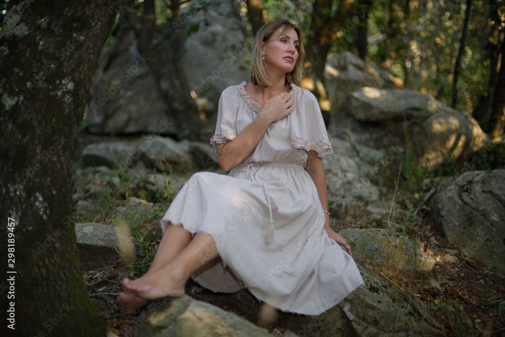 Woman in a forest sitting and relaxing as the sun goes down Woman in a forest sitting and relaxing as the sun goes down