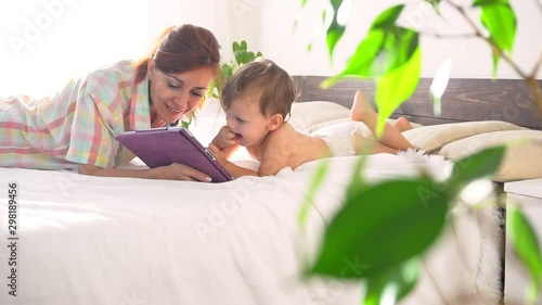Mom and son watch tablet in bedroom