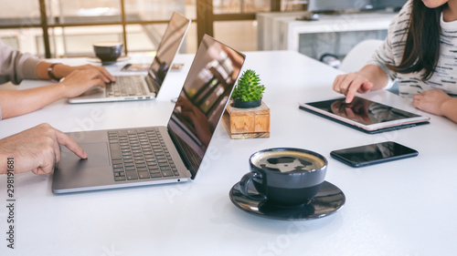People using and working on laptop computer and tablet pc with mobile phone on the table in office