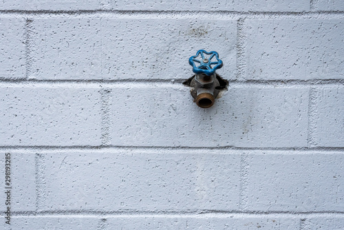Tablou pe pânză Outside faucet on a blue gray painted brick wall