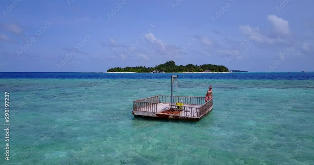 Young girl relaxing at sun deck in the middle of the water off the coast of secluded beach in the Bahamas Young girl relaxing at sun deck in the middle of the water off the coast of secluded beach in the Bahamas