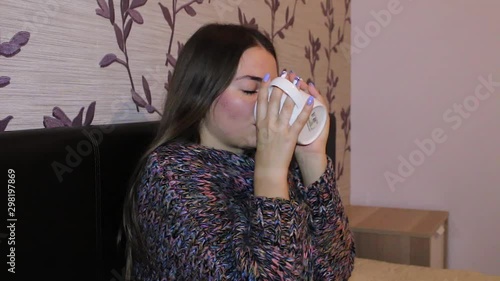 Teenage girl freezing while sitting in her room with a cup of tea, autumn photo