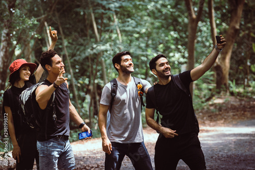 Group of traveler people selfie with mobile phone at rain forest together,Happy and smiling,Enjoying backpacking concept