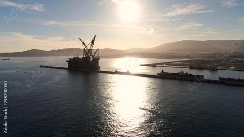 Sunset in port of Algeciras, Spain. Alongside to breakwater pier offshore platform and some vessels.
