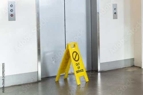 Elevator with an "Out of service" yellow sign in front of it.