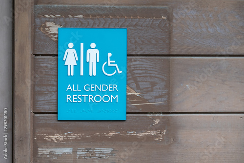 All gender restroom sign with Braille code on the side of the building.