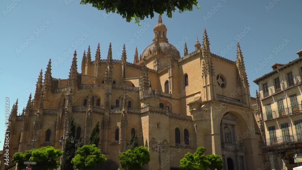 Slow reveal of Segovia cathedral behind trees Slow reveal of Segovia cathedral behind trees