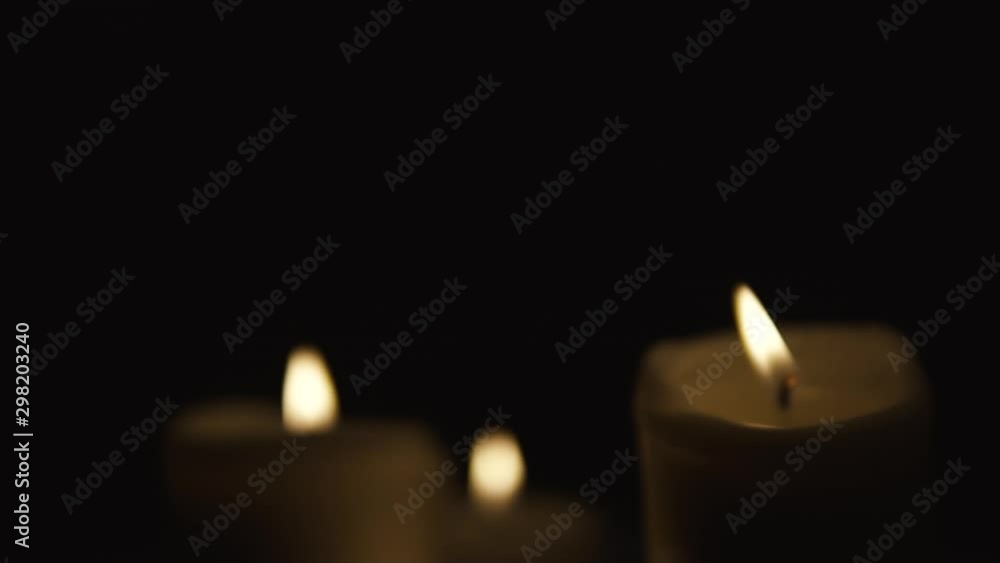 Slide from left to right, and take focusing on burning candles occupy the whole area, composition on black background, take focusing from blurred, slow motion Slide from left to right, and take focusing on burning candles occupy the whole area, composition on black background, take focusing from blurred, slow motion