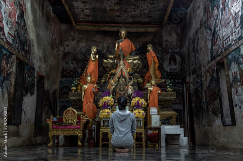 Young woman sitting praying pay respect to Buddha statue in the .Wat Kongkharam Rajavaravihara (Photharam) Ratchaburi. Worship pray photo