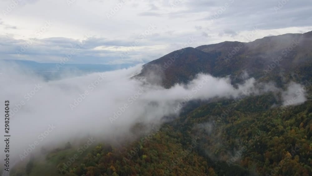 Drone aerial view of an Alpine aerial misty forest in the Swiss french Jura mountains. The forest canopy is a variety of fall colors. Drone aerial view of an Alpine aerial misty forest in the Swiss french Jura mountains. The forest canopy is a variety of fall colors.