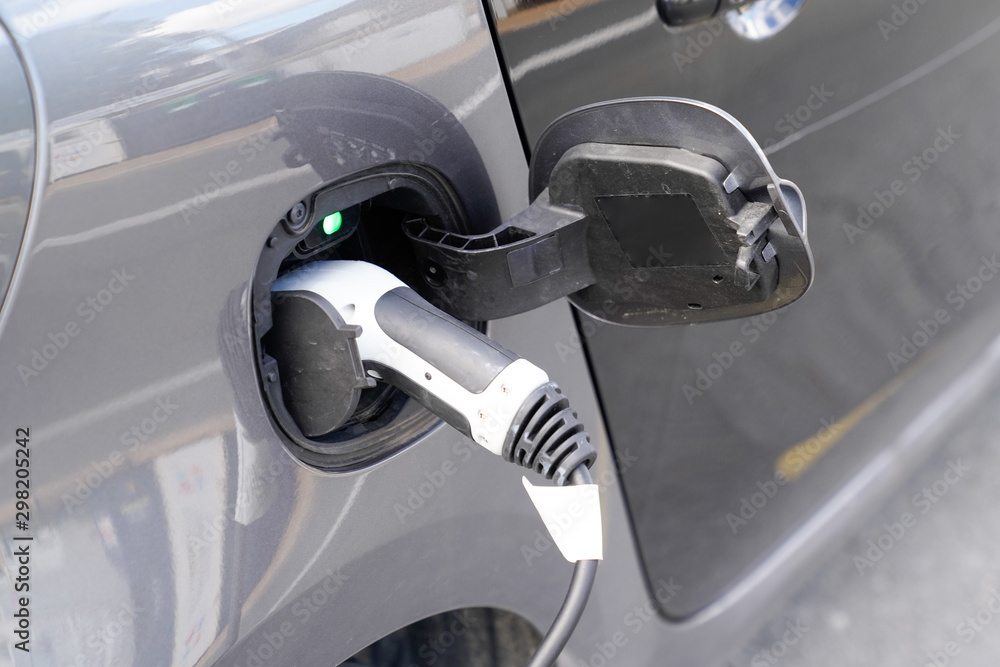 charging station power supply plugged into an electric car charged charging station power supply plugged into an electric car charged